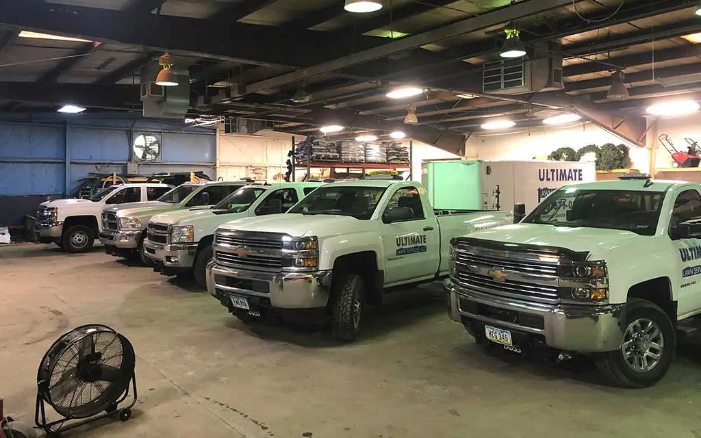 Ultimate Lawn Services work trucks at a shop in Urbandale, IA.