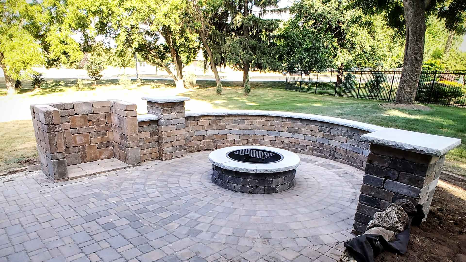 Custom built fire pit made out of stone with seating wall installed in Urbandale, IA.