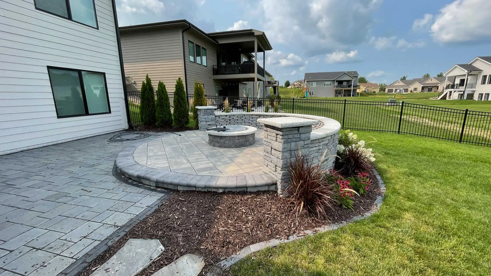 Custom patio and fire pit with a seating wall near Waukee, IA.