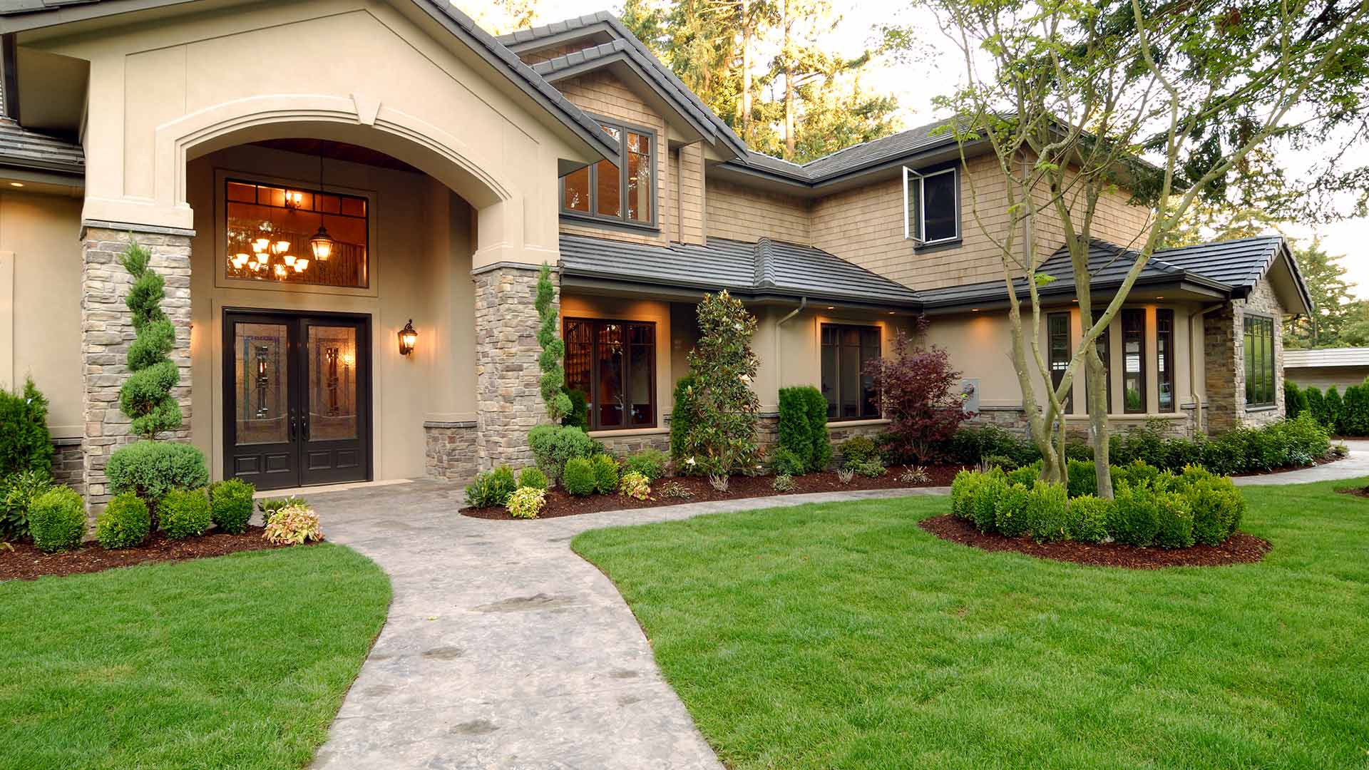 A beautiful home with a healthy lawn and landscape bed plants in Johnston, IA.