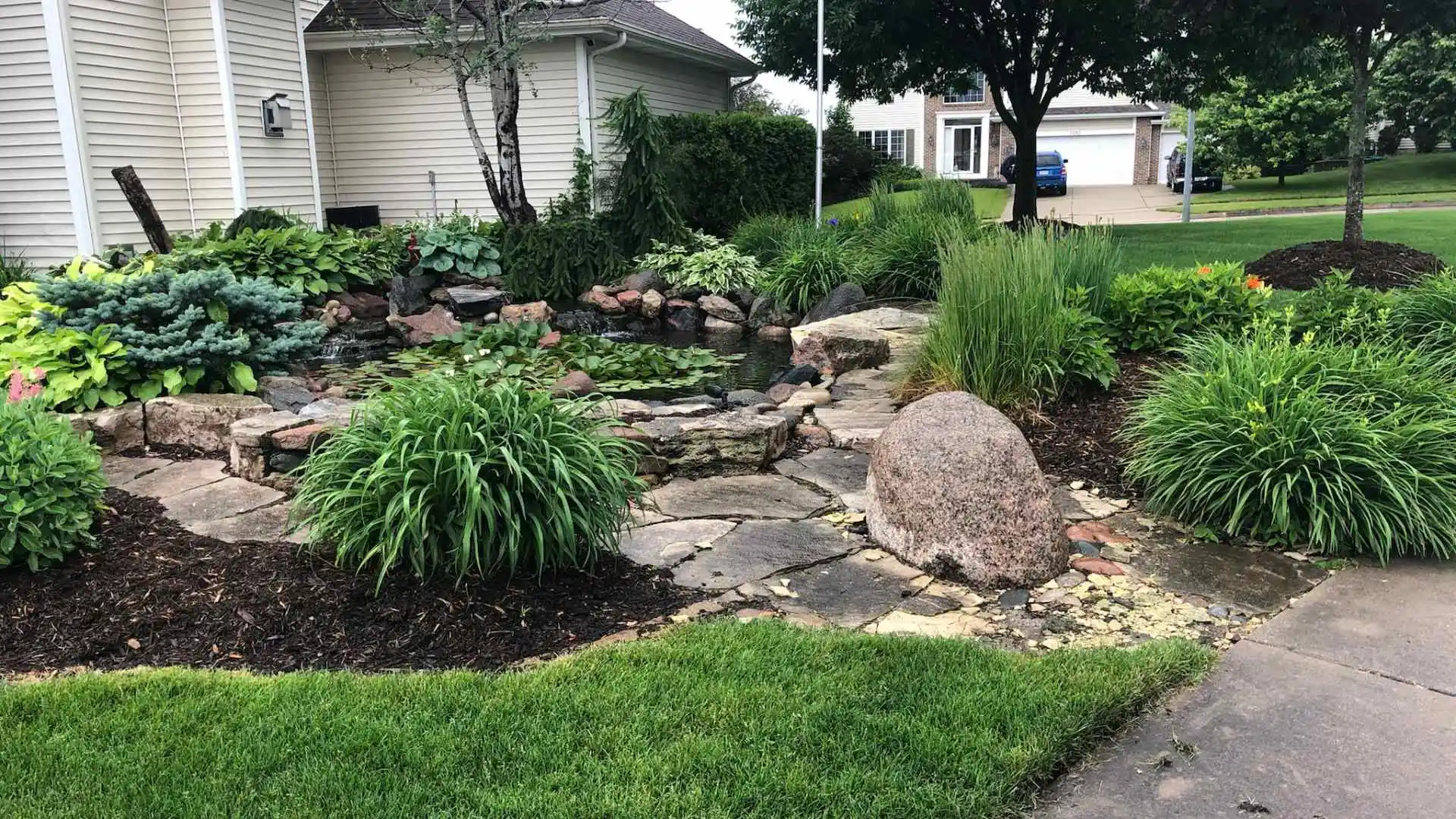 Landscape with plantings and water feature installed in Ankeny, IA.