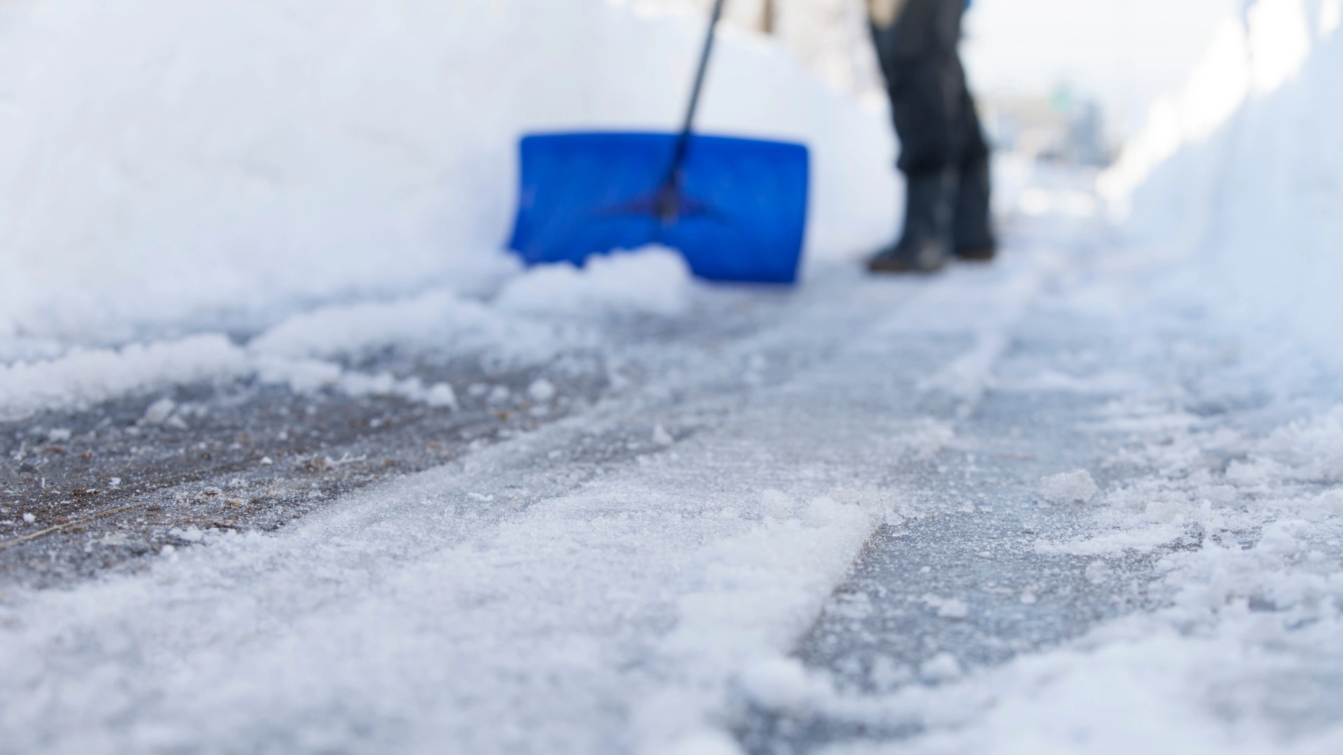 Professional shoveling a walkway at a residential home in Waukee, IA.