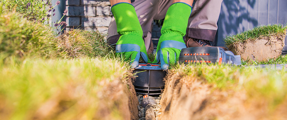 Professional installing a lawn irrigation system in the ground in the Norwalk, IA area.