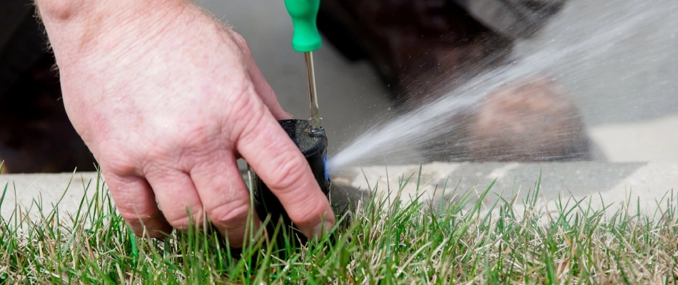 Broken irrigation sprinkler being repaired by professional in Waukee, IA.