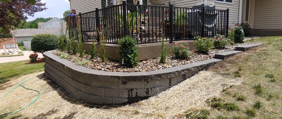 Retaining wall with plantings off of patio area into lawn in Des Moines, IA.