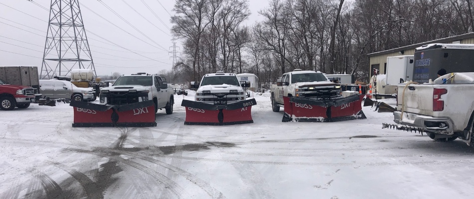 Snow plow trucks lined up to service a commercial property with snow removal in Grimes, IA.