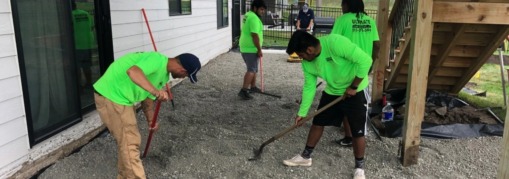 Ultimate employees working together on backyard patio in Grimes, IA.