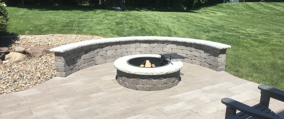Custom built wood burning fire pit with seating wall in Grimes IA.